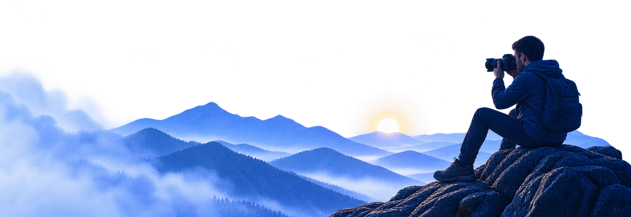 Photographer overlooking mountain landscape at sunset